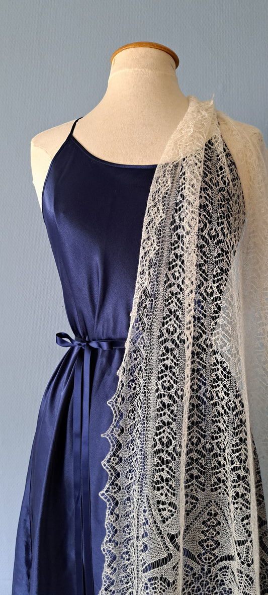 A gossamer cashmere shawl draped over a royal blue dressed mannequin
