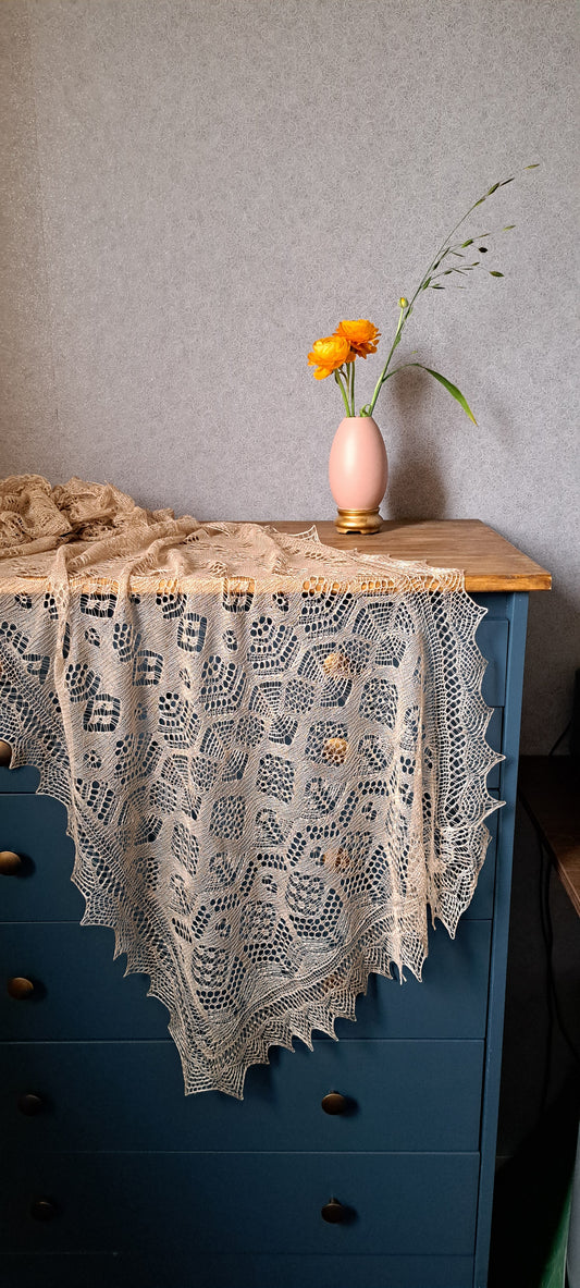 a beige lace shawl, draped on a blue drawer and orange flowers