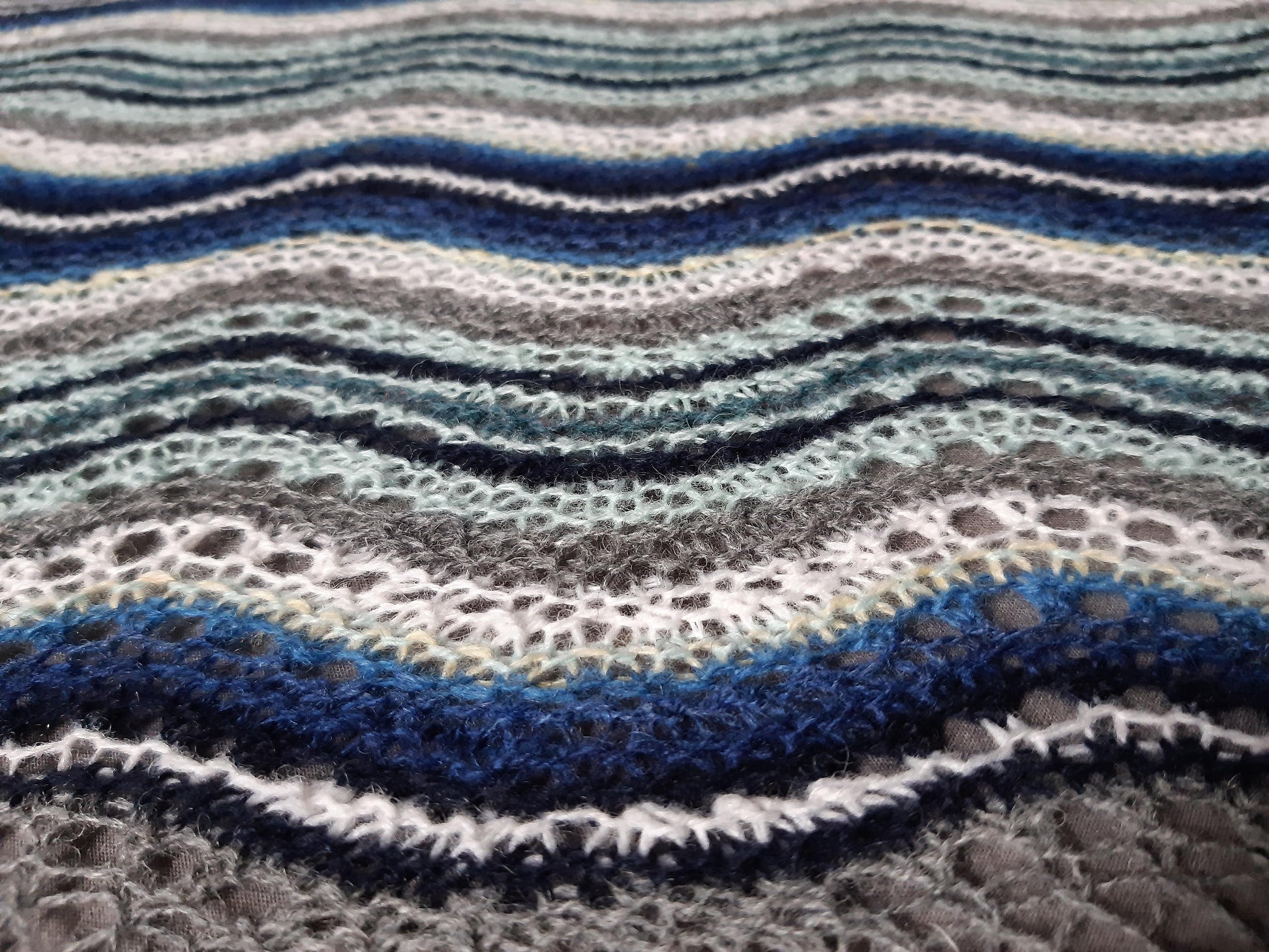 knit shawl in many blue colours in a wave pattern